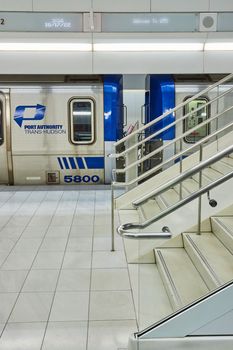 Clean modern subway train stairs up from side and Port Authority Trans-Hudson blue train waiting