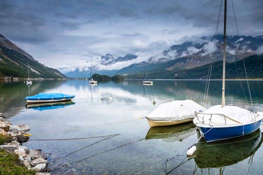 Sailboat anchored on Silvaplana Lake at misty dawn, Swiss Alps, Switzerland