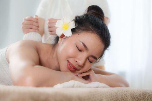 Young woman doing relaxing massage in spa salon. Female being massaged by a masseur. Spa and medicine concept.