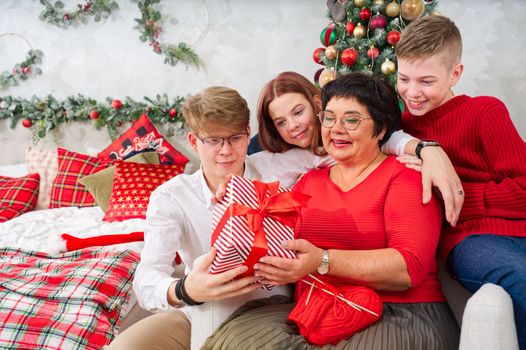 Mother with three children unpacks a christmas gift. christmas wonder