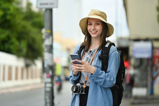 Smiling caucasian woman traveller using smart phone, enjoying new adventure during holiday time