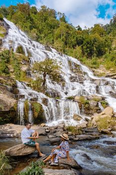 A couple man and a woman visiting a waterfall in Thailand, Mae Ya Waterfall Doi Inthanon Chiang Mai