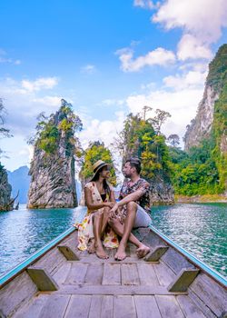 couple traveling by longtail boat Khao Sok National Park, Chiew lan lake, Thailand