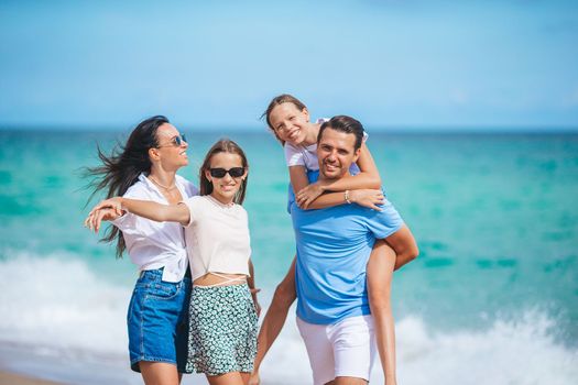 Family of four have fun together on beach vacation on Caribs