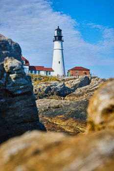Lighthouse in Maine through soft focused rocks