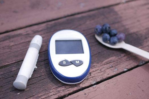 Close up of diabetic measurement tools and blue berry on table 