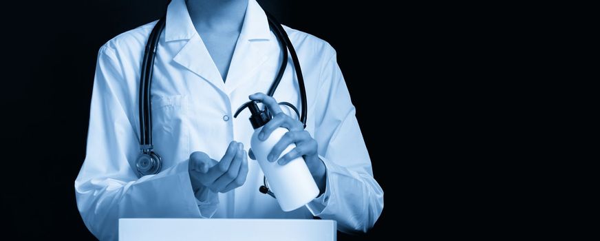 doctor applying antibacterial spray on hand on black background