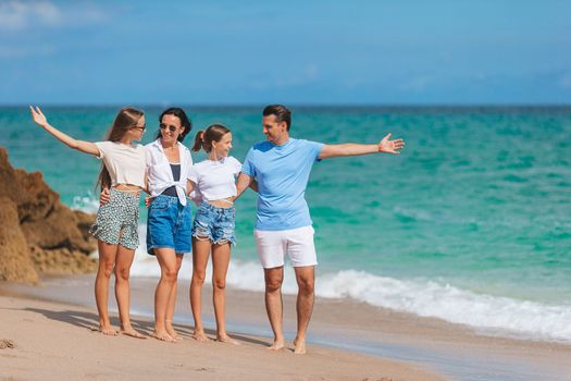 Family of four have fun together on beach vacation in Florida