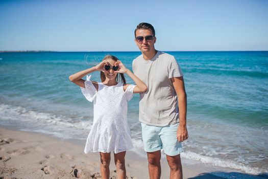 Young father and little daughter on the beach enjoy their time together