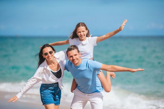 Happy family of three on the beach during summer vacation