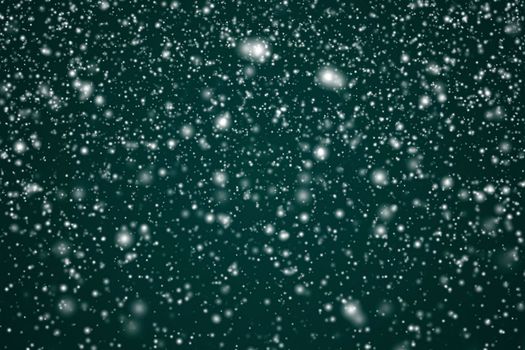 Winter holidays and wintertime background, white snow falling on festive green backdrop, snowflakes bokeh and snowfall particles as abstract snowing scene for Christmas and snowy holiday design