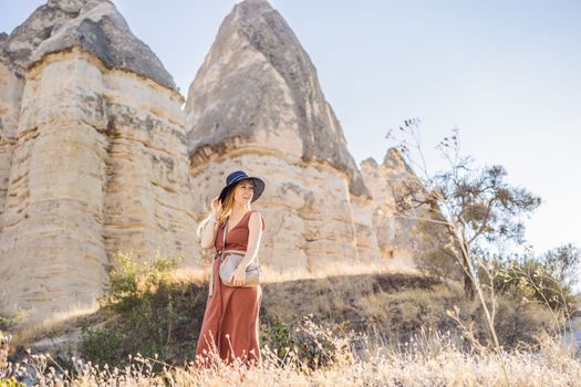 Woman tourist on background of Unique geological formations in Love Valley in Cappadocia, popular travel destination in Turkey
