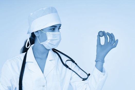 Doctor holding in hands wearing medical gloves three-dimensional blue model of virus - coronavirus COVID-19