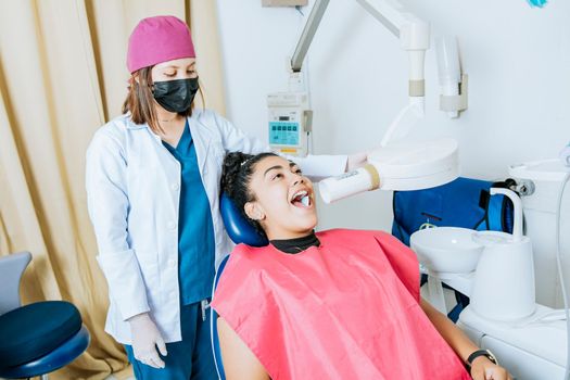 Dentist performing intraoral dental x-ray on a patient, Dentist performing intraoral x-ray assessment on a patient, a dentist performing dental x-rays in the office. Intraoral radiography concept