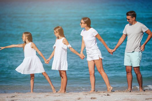 Young family walking on the beach on summer vacation