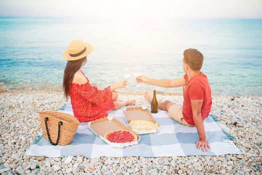 Lovely young couple having a picnic at the beach 