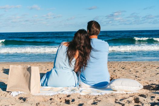 Young couple in love on the beach summer vacation. Happy man and woman look at the sea 