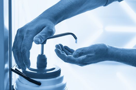 Mechanic applying washing soap to clean dirty hands after work