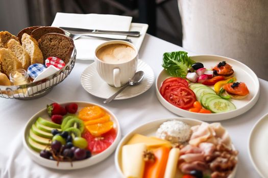 Luxury hotel and five star room service, various food platters, bread and coffee as in-room breakfast for travel and hospitality
