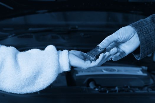 Mechanic giving car keys to customer after servicing
