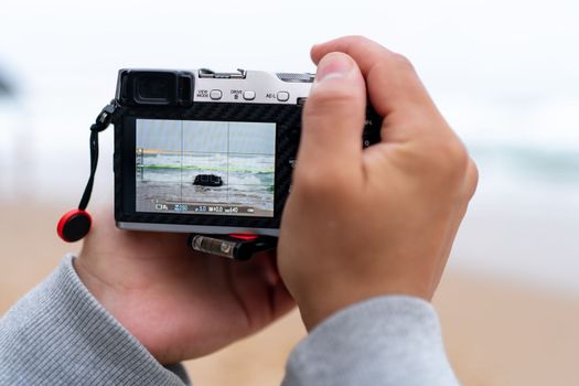 Traveller make photo holding mirrorless camera in hand