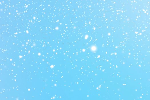 Winter holidays and wintertime background, white snow falling on blue backdrop, snowflakes bokeh and snowfall particles as abstract snowing scene for Christmas and snowy holiday design