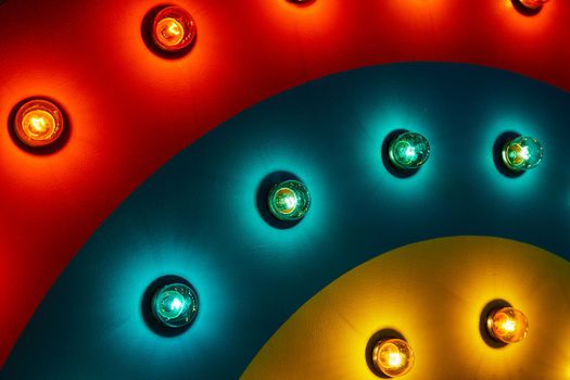 Detail of light bulbs on rainbow wave of red, blue, and yellow