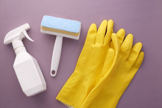 window cleaning spray, brush and gloves on purple background 