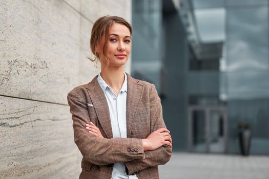 Businesswoman successful woman business person standing arms crossed outdoor corporate building exterior. Smile happy caucasian confidence professional business woman middle age