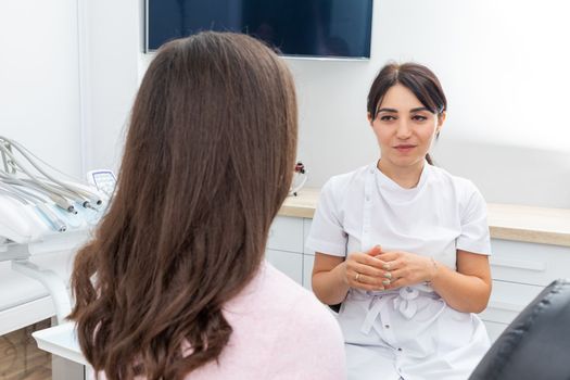 Female dentist explaining patient treatment during an appointment in dental clinic