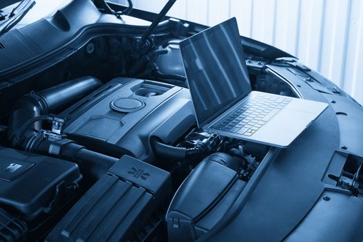 Laptop on a car in auto repair shop, Automobile mechanic repairman concept
