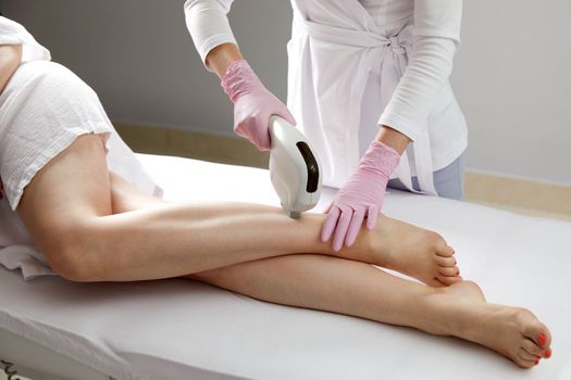 Laser hair removal on ladies legs in beauty salon