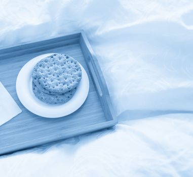 Tray with water and crackers dbreakfast on a bed