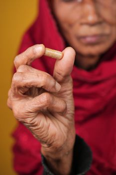senior asian women holding a herbal medicine capsule 