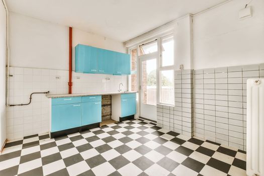 a kitchen with checkered floor and blue cabinets