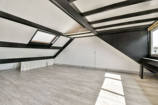 a large white room with wood floors and black beams
