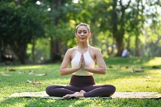 Healthy beautiful woman practicing yoga, meditating with closed eyes. Health lifestyle and Mindfulness meditation concept.