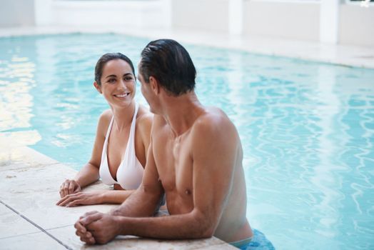 She enjoys his company at the pool. a loving mature couple relaxing in a pool.