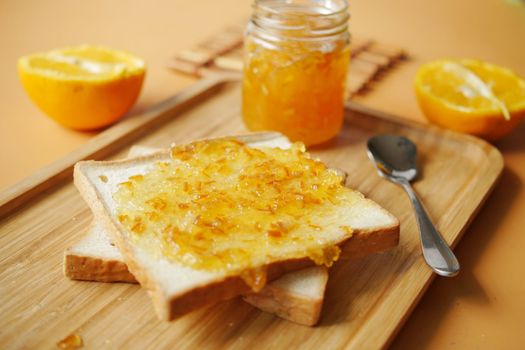 orange fruit spread on a bread on table 