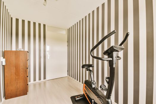 a gym with a exercise bike and striped walls