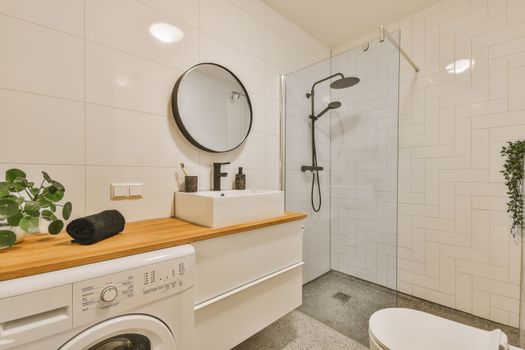 a white bathroom with a washing machine and a shower
