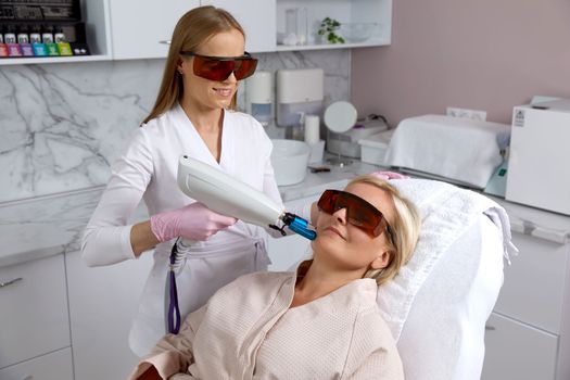 Woman receiving laser treatment in cosmetology clinic