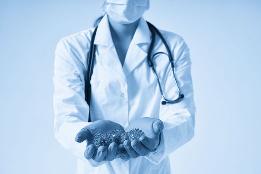 Doctor holding in hands wearing medical gloves three-dimensional blue model of virus - coronavirus COVID-19