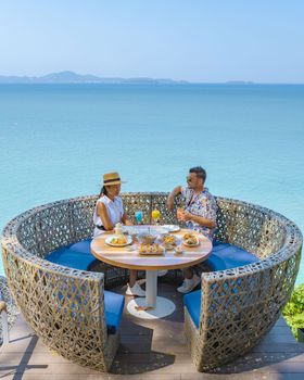 couple having lunch at an restaurant looking out over the ocean of Pattaya Thailand