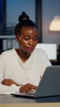 Stressed african manager woman working with financial graphs overtime
