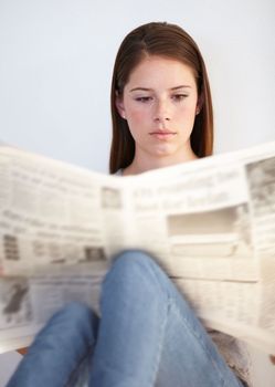 Reading the morning paper. A young woman reading the morning paper.