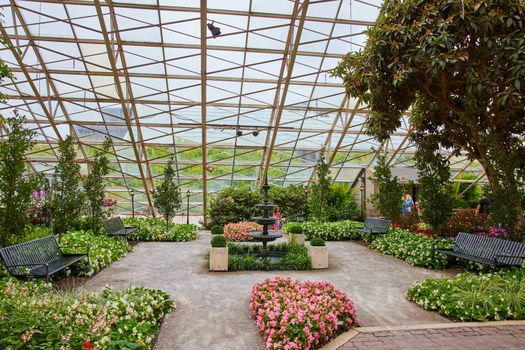 Beautiful botanical gardens with glass ceiling and tiered fountain