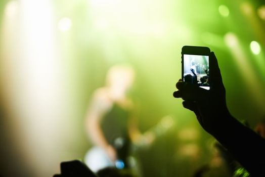Capturing the moment. A person filming their favourite band with a camera phone