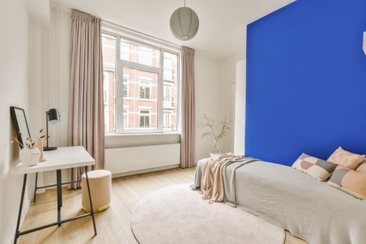 a bedroom with a blue accent wall and a bed
