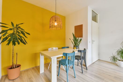 a dining room with yellow walls and a white table